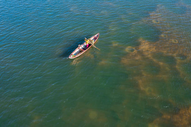 Drone view of a fisherwoman is putting fishing trap on Tra Khung river, Quang Ngai province, central Vietnam