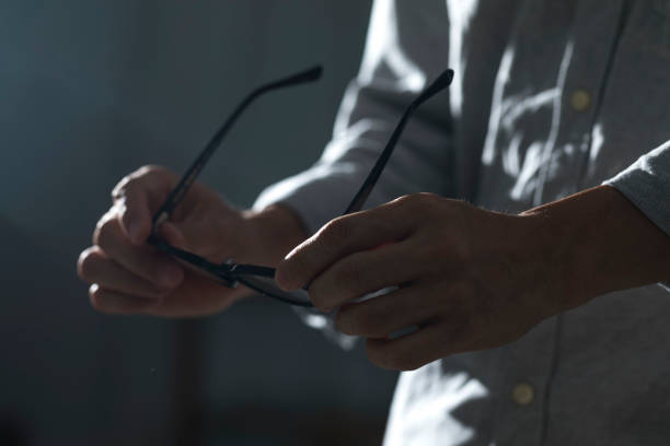 istock hand holding eyeglass in dark background. 1335522026