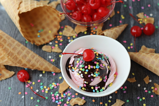 Homemade strawberry ice cream with chocolate syrup and sugar sprinkles