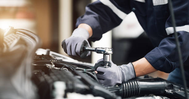 il meccanico lavora sul motore dell'auto nel garage. servizio di riparazione. concetto di servizio di ispezione auto e servizio di riparazione auto. - auto mechanic foto e immagini stock