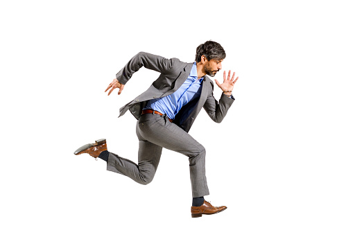 Stylish businessman in a suit running at speed in a mid air stride isolated on white conceptual of ambition, deadlines, urgency and being late for an agenda