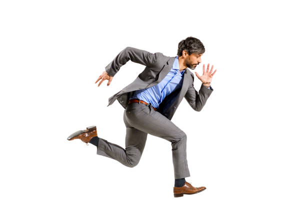 Stylish businessman running at speed in a mid air stride Stylish businessman in a suit running at speed in a mid air stride isolated on white conceptual of ambition, deadlines, urgency and being late for an agenda sprinting photos stock pictures, royalty-free photos & images
