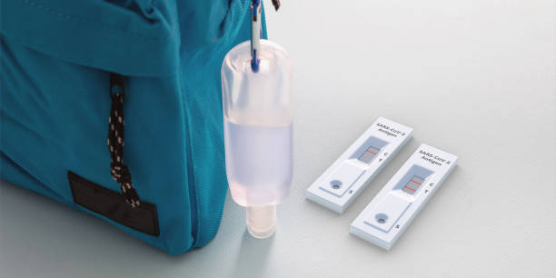 istock School Covid 19 protection. Rapid test, hand sanitizer and student backpack on white color background. 3d illustration 1335530431