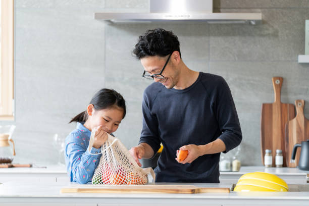 Young girl helping her father to unpack groceries Young girl helping her father to unpack groceries. Okayama, Japan. 2021 child japanese culture japan asian ethnicity stock pictures, royalty-free photos & images