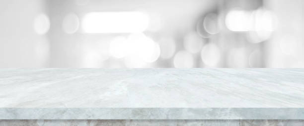 istock Empty white table top, counter, desk over blur perspective store with bokeh light background, White marble stone table, shelf and blurred shop for food, product display mockup, template backdrop, banner, Retail business wallpaper, poster 1335536428