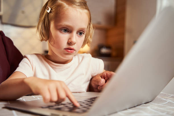 istock Focused child pressing one button on laptop keyboard 1335538115