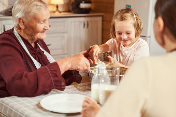istock Glad girl putting water inside metal bowl while preparing dough 1335538189