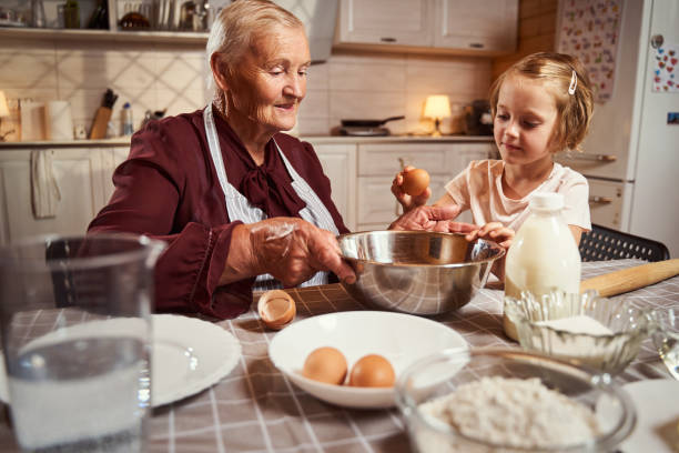 istock Granny letting her granddaughter try breaking an egg 1335538249