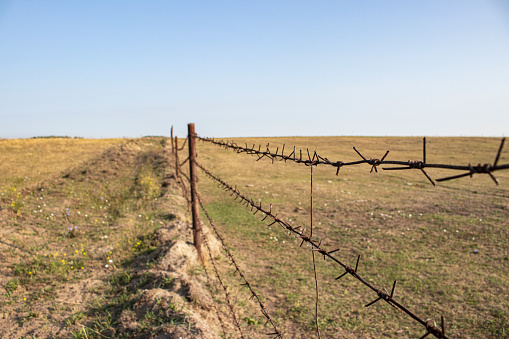 The border of the desert steppe territory is divided by barbed wire.