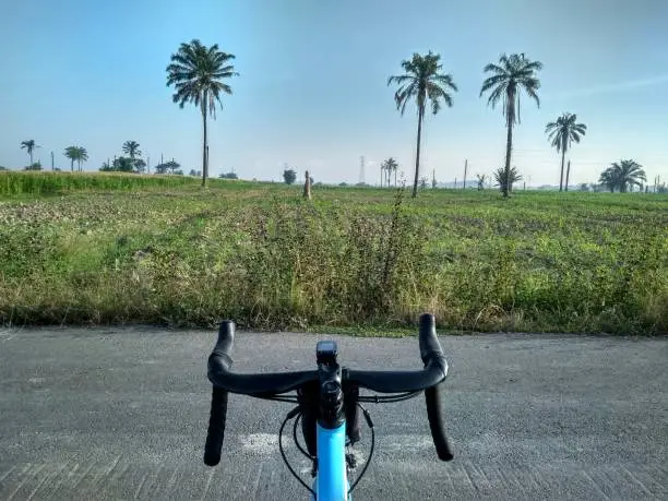 View of an empty field that has not been planted with plants from a bicycle handlebar view