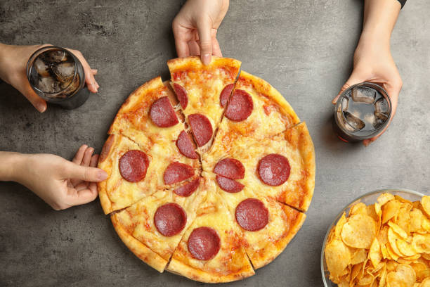 istock Women taking tasty pepperoni pizza at grey table, top view 1335545685