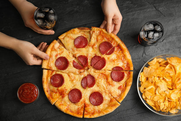 istock Women taking tasty pepperoni pizza at grey table, top view 1335545715