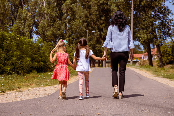 istock Preschool teacher holding hands with her student while she follows them home 1335546898