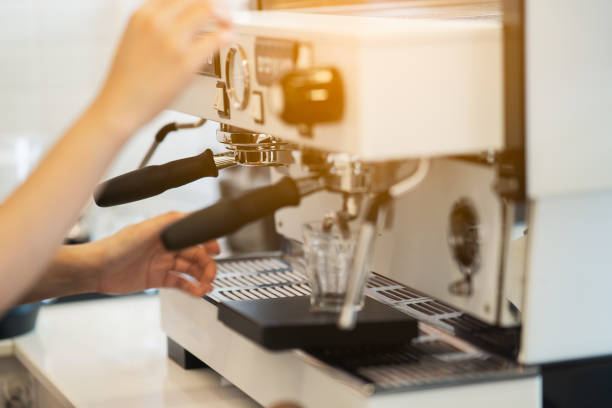 istock women barista making coffee in a coffee machine, coffee making concept 1335549208