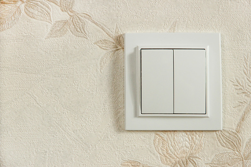 White two rocker switch on the wall close up