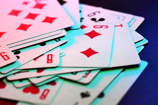 Playing cards in colored lighting.