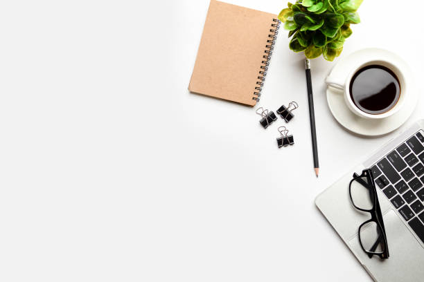 istock Flat lay, top view office table desk. Workspace with blank, office supplies, pencil, green leaf, and coffee cup on white background. 1335553207