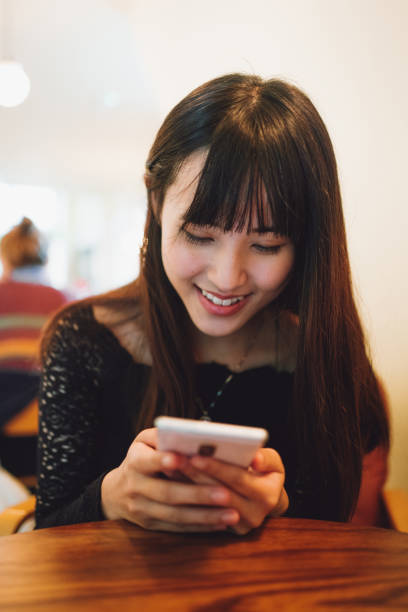 istock Asian beautiful woman using smartphone inside a cafe 1335555611