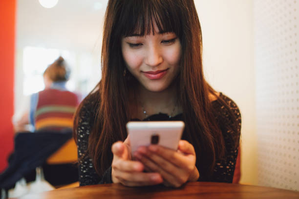 istock Asian beautiful woman using smartphone inside a cafe 1335555627