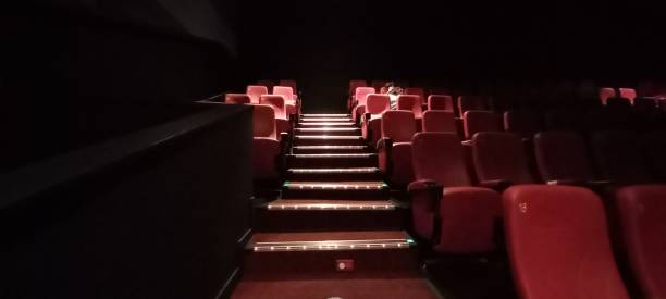 istock Inside a dark movie theater. a red chair 1335558441