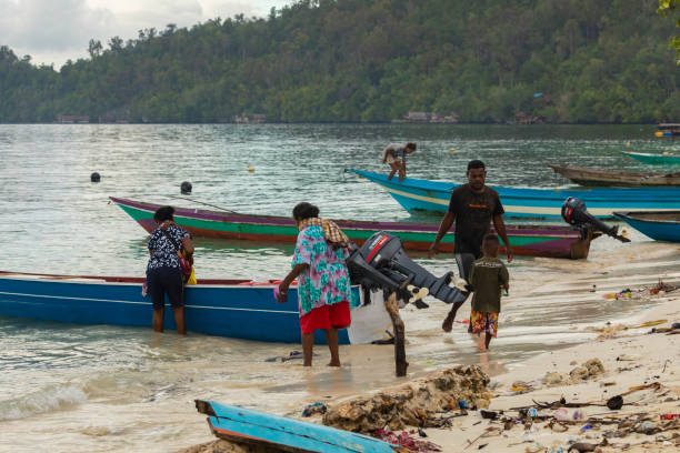 eine familie steigt in ein boot, bereit abzufahren, raja ampat - depart stock-fotos und bilder