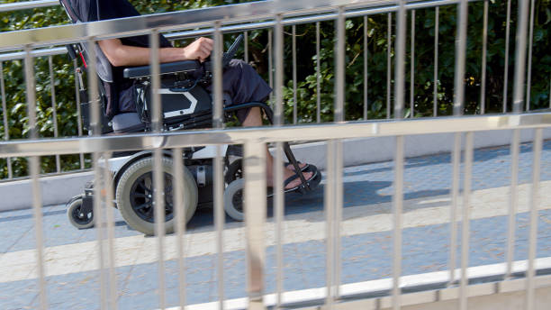 Man on wheelchair driving on accessible ramp