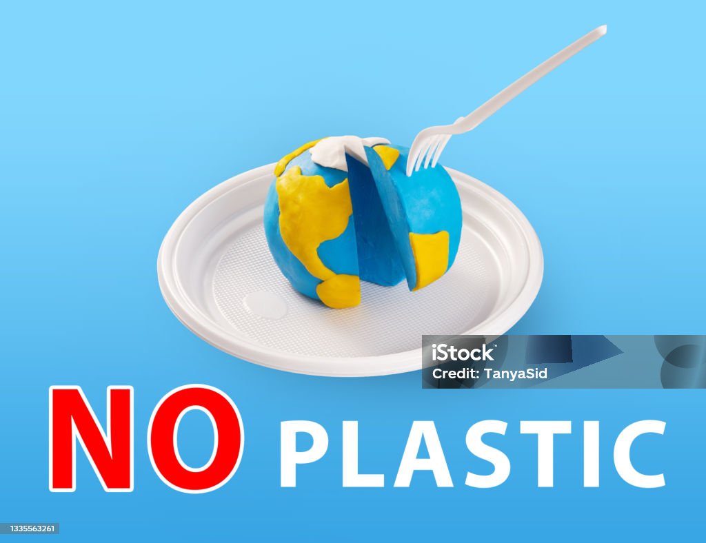 WorldEarth Day concept. Plastic free concept. Pollution problem concept. A plastic plug stuck into the planet Earth. Plasticine earth model on a plastic plate Concepts Stock Photo