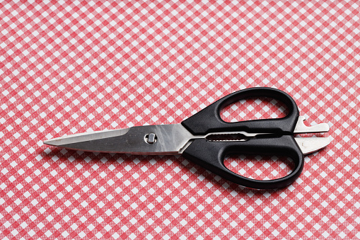 Black handle scissors on a tabletop.