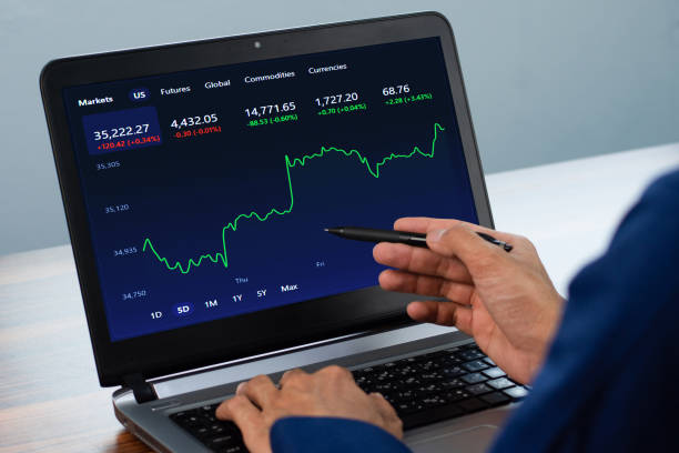 istock Man point on screen digital chart trading online at home 1335564238
