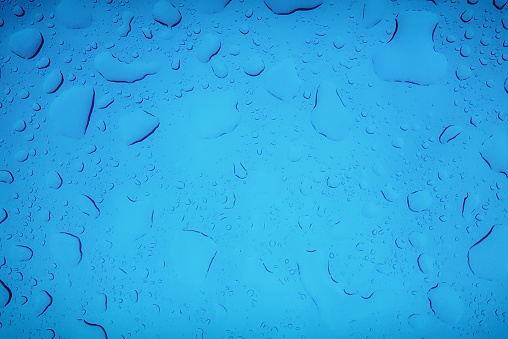 Gotas de lluvia sobre vidrio azul photo