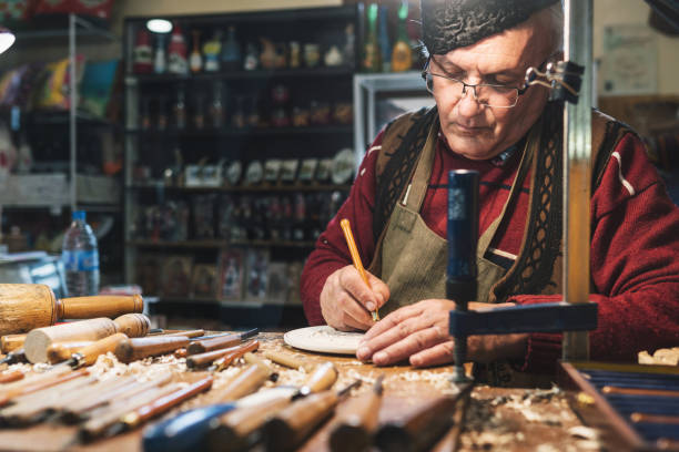 istock Senior carpenter making wood figurine 1335570161