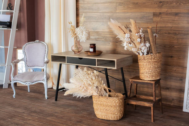 istock Scandinavian style home office interior. Work from home. Interior workspace home.  Cozy design room home in brown tones: wooden table, armchair, wicker baskets with dried flowers and pampas grass. 1335585976