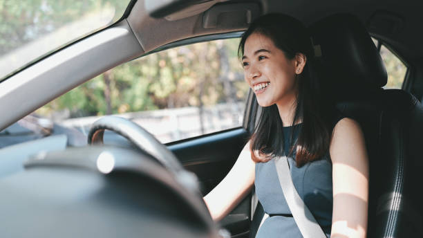 jeune femme conduisant une voiture de retour à la maison après le travail dans la ville d’embouteillage nocturne à bangkok en thaïlande - traffic jam traffic car city photos et images de collection