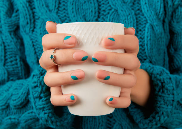 Womans hands with blue manicure holding cup. Trendy winter autumn nail design Womans hands with blue manicure holding cup. Trendy winter autumn nail design. Beauty treatment concept fall nail art stock pictures, royalty-free photos & images