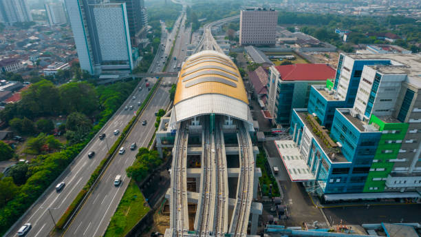 vue aérienne du quai de la gare du tlr sur la nouvelle construction à jakarta - looking at view railroad station street railroad track photos et images de collection