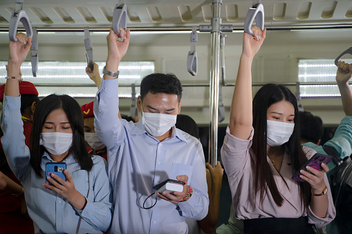 People wear protective face mask during stay on commercial train. COVID-19 and pandemic crisis. Public transportation.