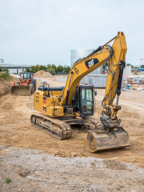 canteiro de obras com máquinas de construção, escavadeiras, escavadeiras e caminhões - caterpillar truck - fotografias e filmes do acervo