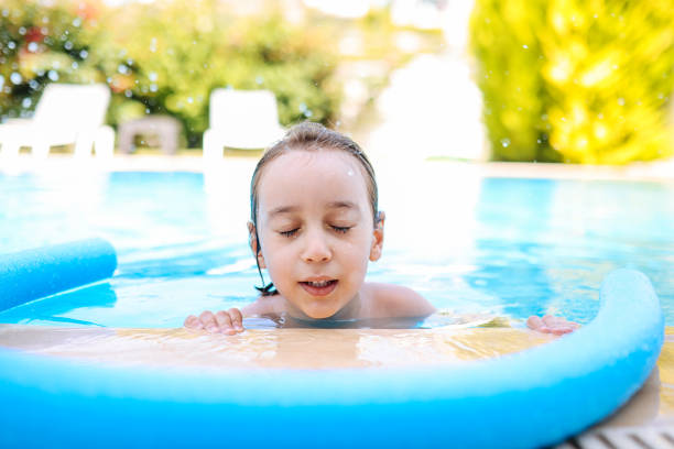 istock Happy laughing toddler boy having fun in a swimming pool 1335660159