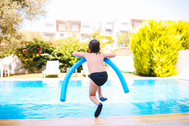 istock Happy laughing toddler boy having fun in a swimming pool 1335660313