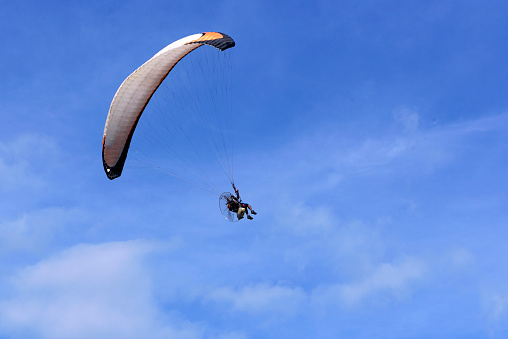 Paraglider flying in a clear sky