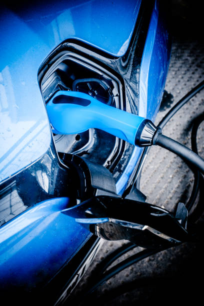 Aberdeen, United Kingdom: August 21, 2021: Blue colored electric car being recharged with a blue colored power connector on the west side of Level One of the Union Square car park in the city of Aberdeen, Scotland.