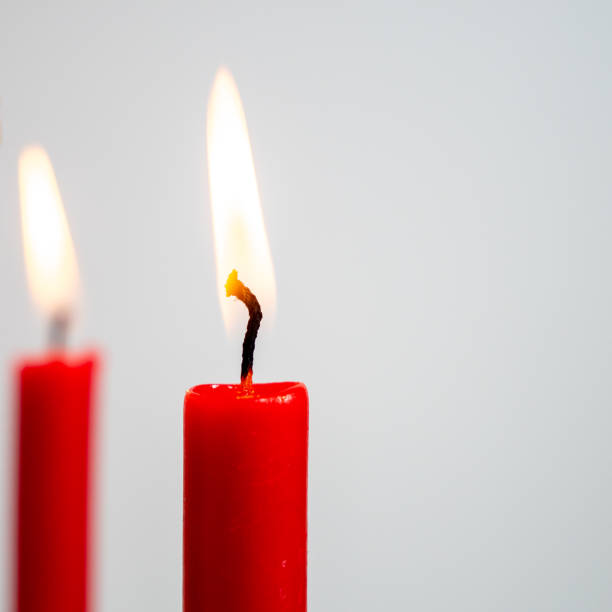 istock Burning red candle on a white background. 1335665600