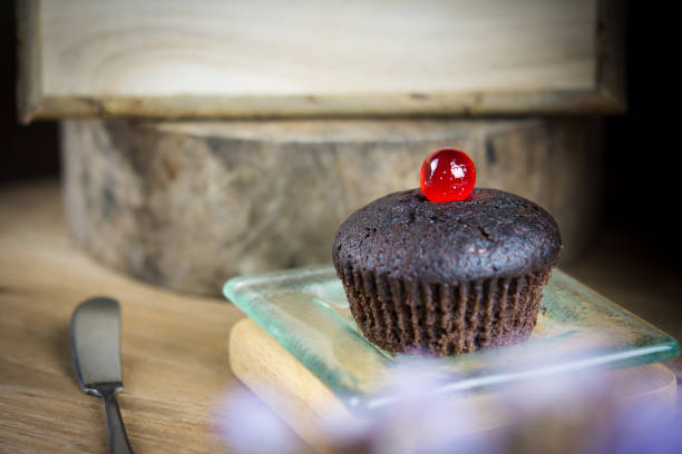 cupcake al cioccolato in un piatto di vetro, atmosfera estiva, giornata calda, concetto di stile di vita. - cupcake crumb sweet wrapper chocolate foto e immagini stock