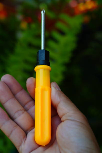 istock Old crosshead screwdriver yellow on hand 1335668844