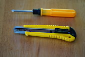 Yellow crosshead screwdriver and cutter on table