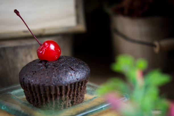 cupcake al cioccolato in un piatto di vetro, atmosfera estiva, giornata calda, concetto di stile di vita. - cupcake crumb sweet wrapper chocolate foto e immagini stock