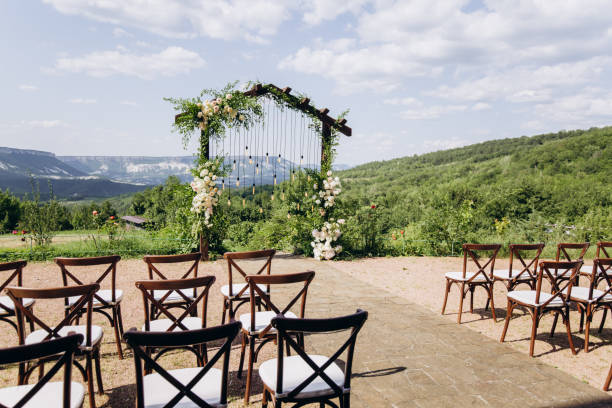 istock Wedding arch on rustuc style with white flowers in park with light bulbs. 1335669394