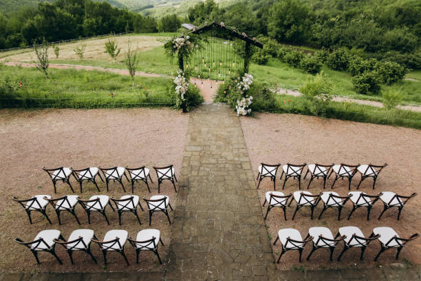 istock Wedding arch on rustuc style with white flowers in park with light bulbs. 1335671717