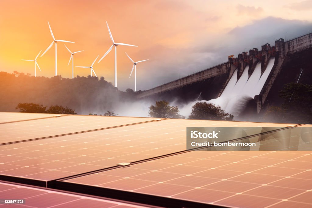 Electricity from solar panels, dams, and wind turbines. Environmentally-friendly renewable energy concept. Renewable Energy Stock Photo