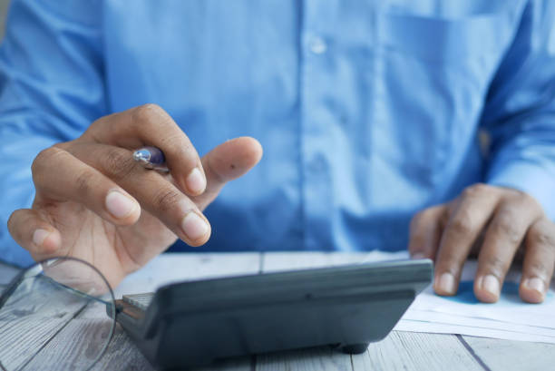 istock Close up of man hand using calculator 1335673729